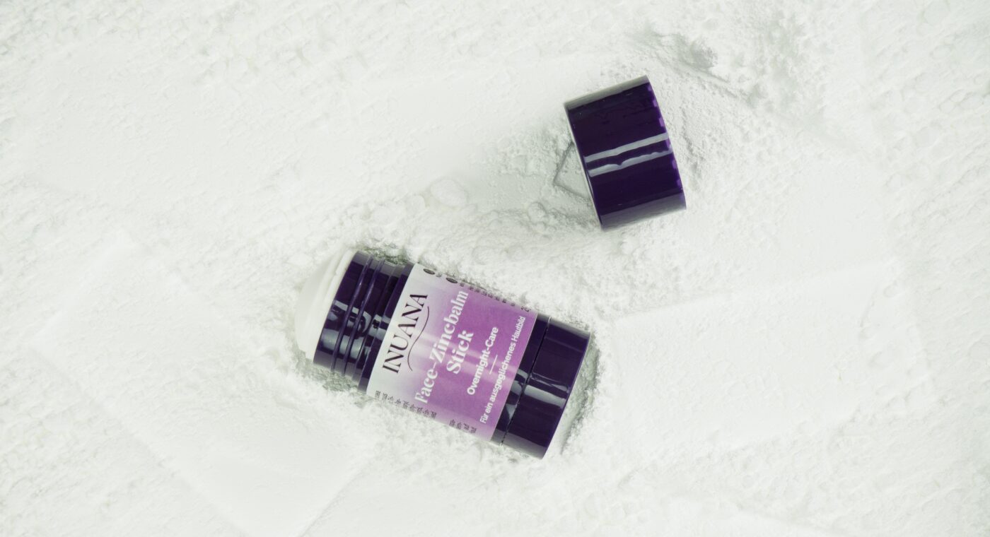 INUANA Face Zinc Balm Stick mit Zinkoxid für empfindliche und unreine Haut auf weißem Zinkpulver.