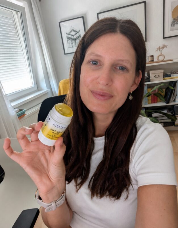 Frau hält den INUANA Jelly Sun Stick LSF 50 in der Hand.