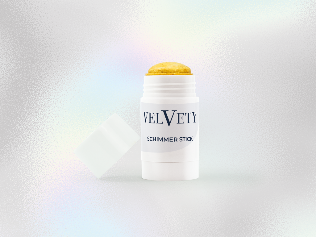 Geöffneter Velvety Schimmer Stick mit goldener Textur in weißer Verpackung.